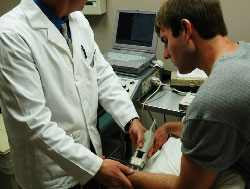 A doctor testing the nerves of his patient with a special machine